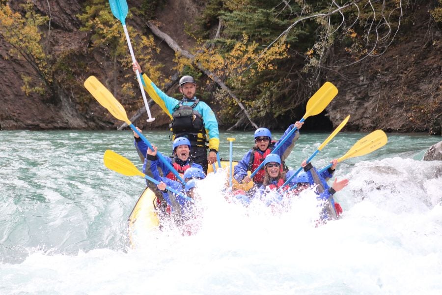 Rafters celebrate conquering a rapid, water splashing all around.