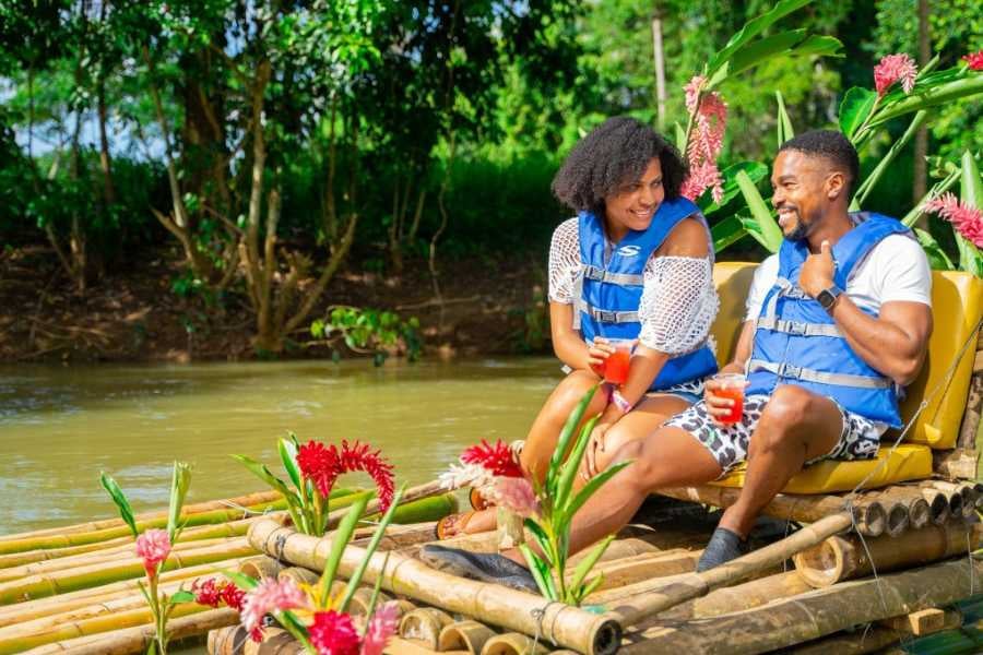 A couple relaxes on a bamboo raft, sipping drinks.