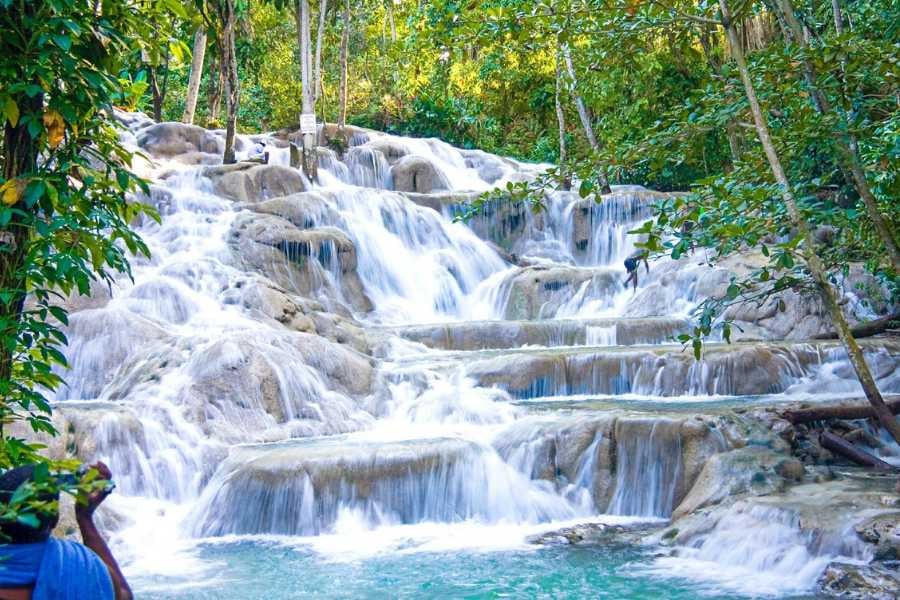 A majestic waterfall tumbles over smooth limestone steps.