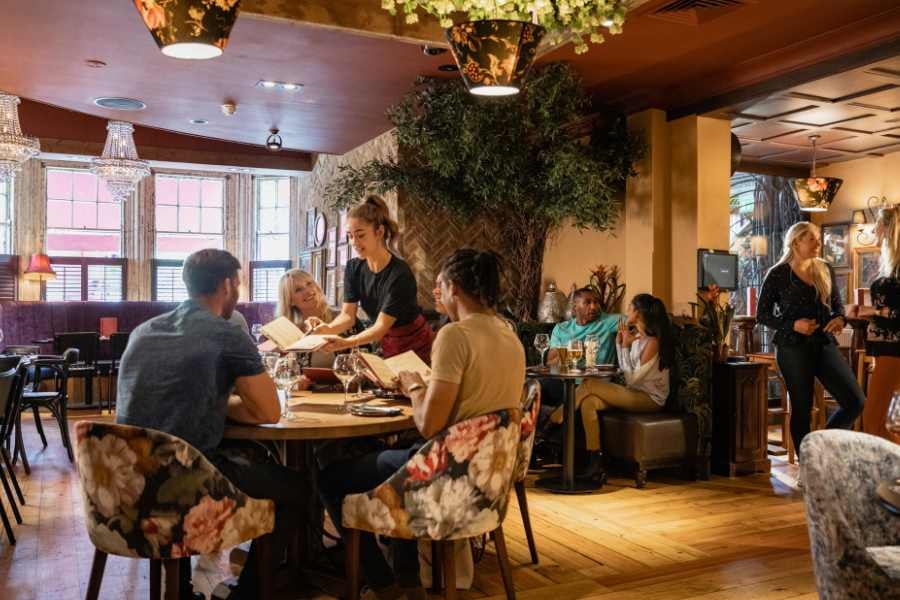 Friends enjoy a meal in a warm, stylish restaurant.