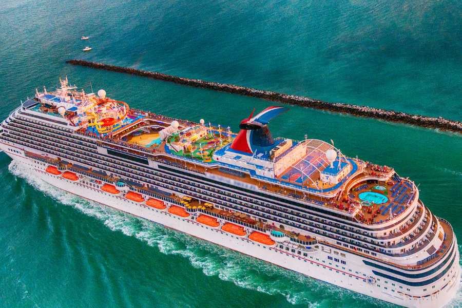 A colorful cruise ship sailing on calm water, full of fun activities.