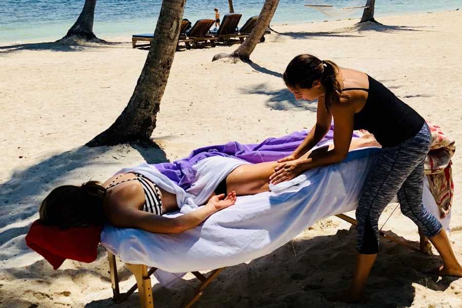 A woman is getting a massage on the beach