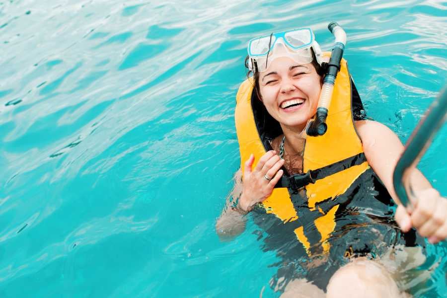 A joyful snorkeler enjoying the crystal-clear waters with a bright smile, fully geared up.