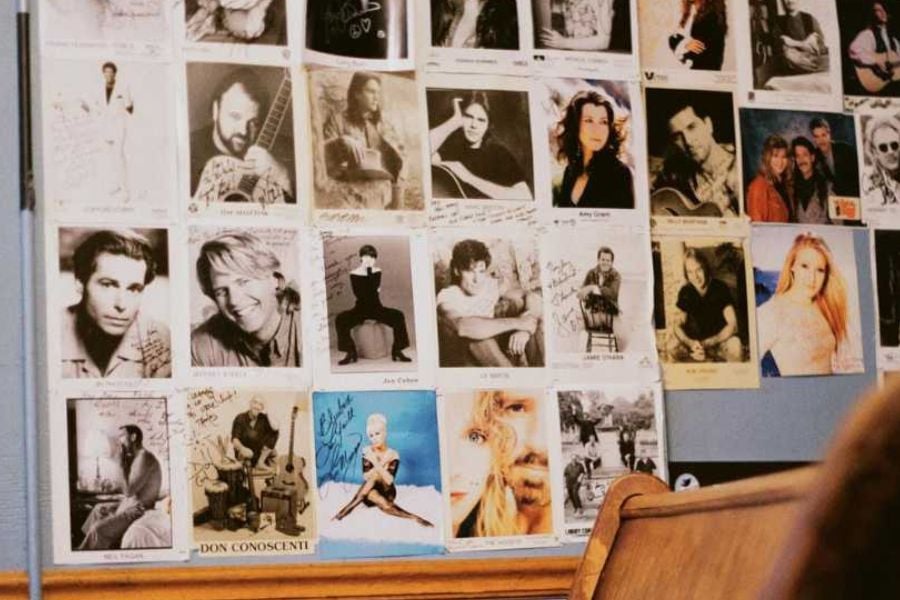 A wall filled with signed photos of famous musicians and performers.