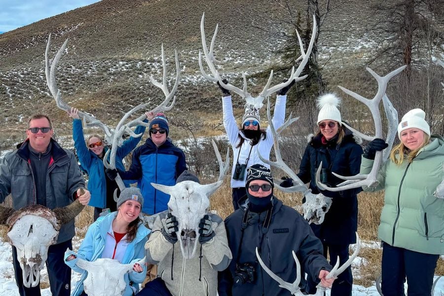 A group proudly shows off shed antlers and skulls.