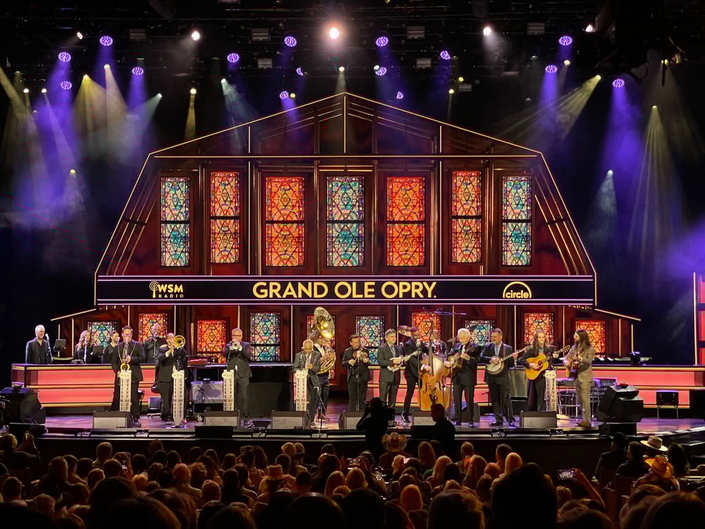 Grand Ole Opry stage decorated for Christmas with musicians performing live