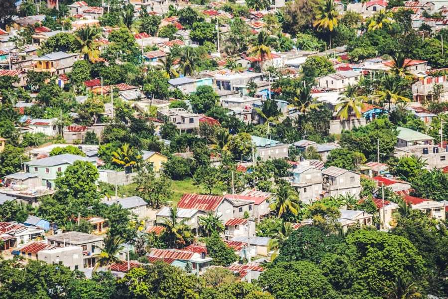 A vibrant view of a colorful neighborhood with rooftops and greenery from above.