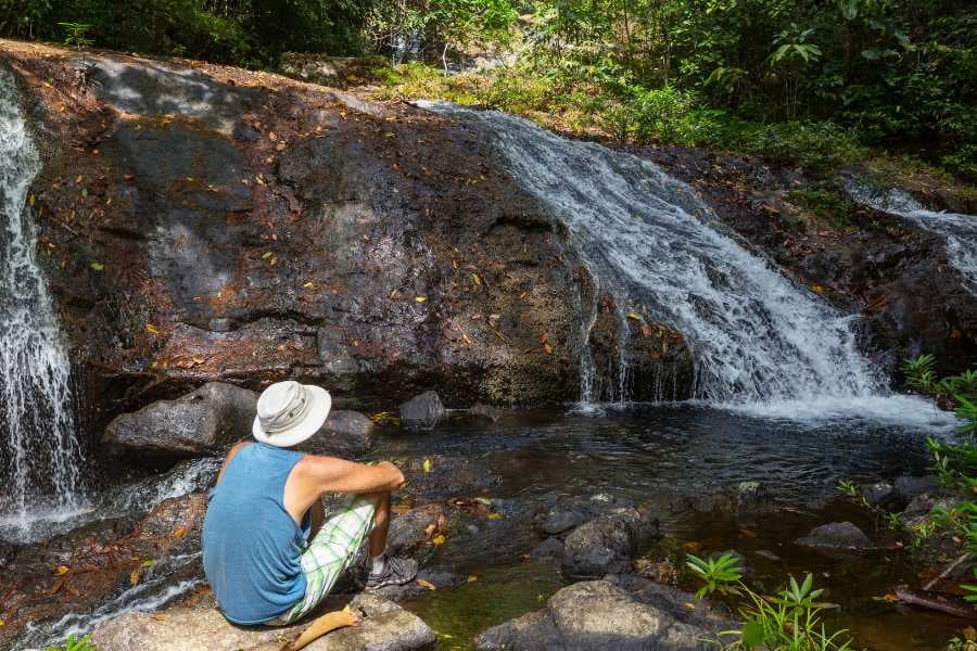 A man is looking at a beautiful view of a waterfall