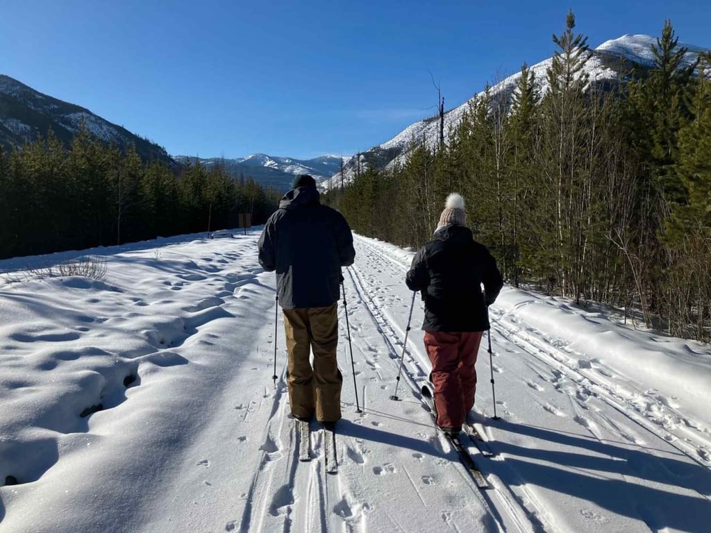 Winter scenery near East Glacier Park, with snow-covered peaks and forested slopes marking the eastern end of the Highway 2 south corridor