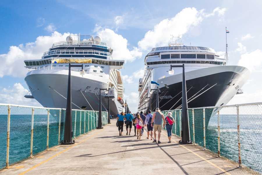 Cruise passengers strolling along a pier, ready for their next tropical adventure under the sunny sky.