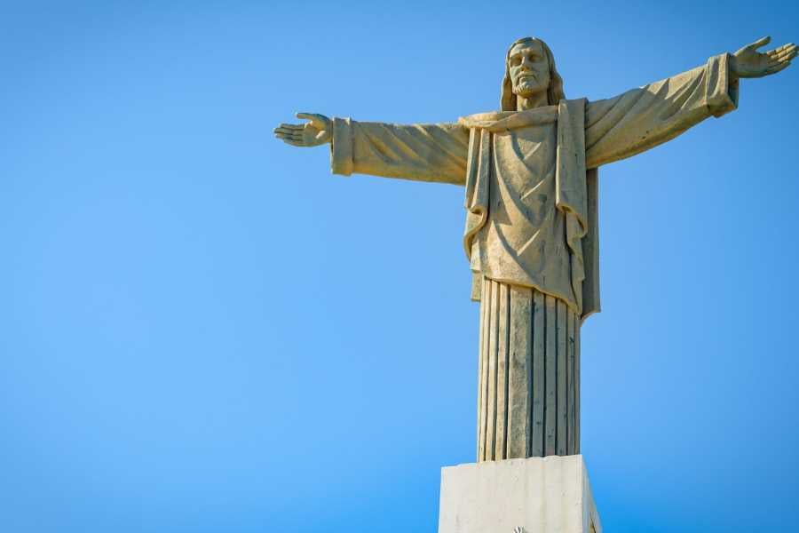 The towering Christ the Redeemer statue stands tall under a clear blue sky.