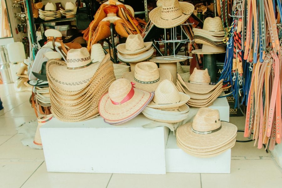 Handcrafted hats are neatly stacked inside a small local shop.