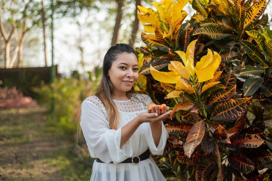 Portrait of young woman next to garden plant