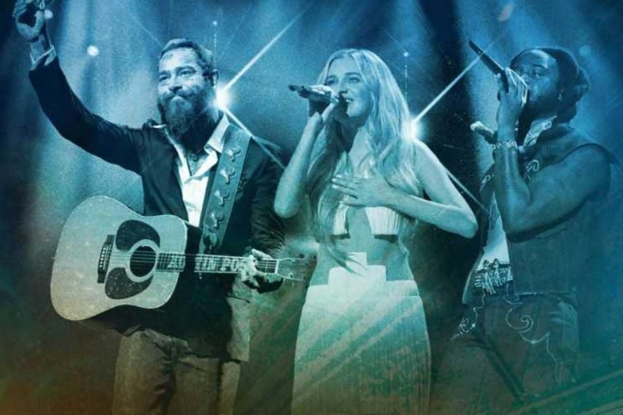 Three singers performing on stage under bright lights and smoky effects.