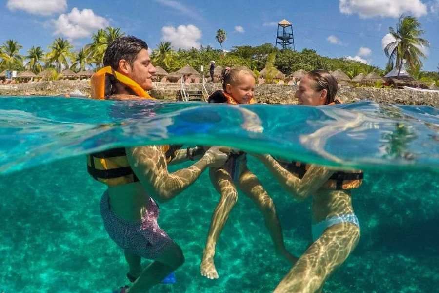 A family enjoys snorkeling and bonding in turquoise waters surrounded by tropical beauty and sunshine.