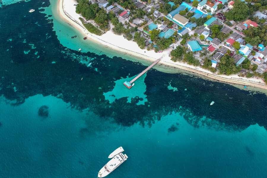 A beautiful aerial view of the vibrant waters and a pier in a coastal town.