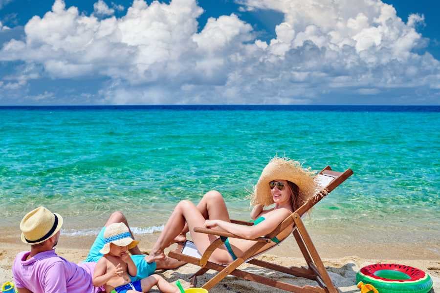 A family relaxes on the white sand by the beach