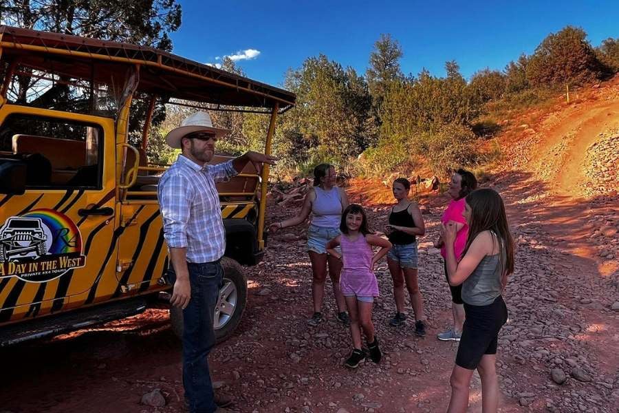 Cowboy guide shares trail tips with a group of excited young adventurers.