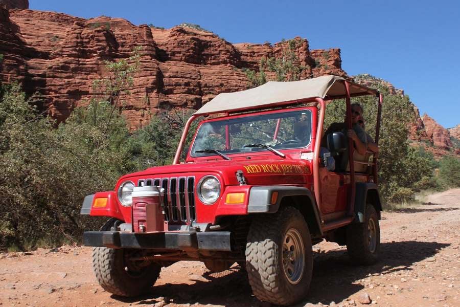 Cruising through red rock canyons on a sunny desert jeep tour adventure.