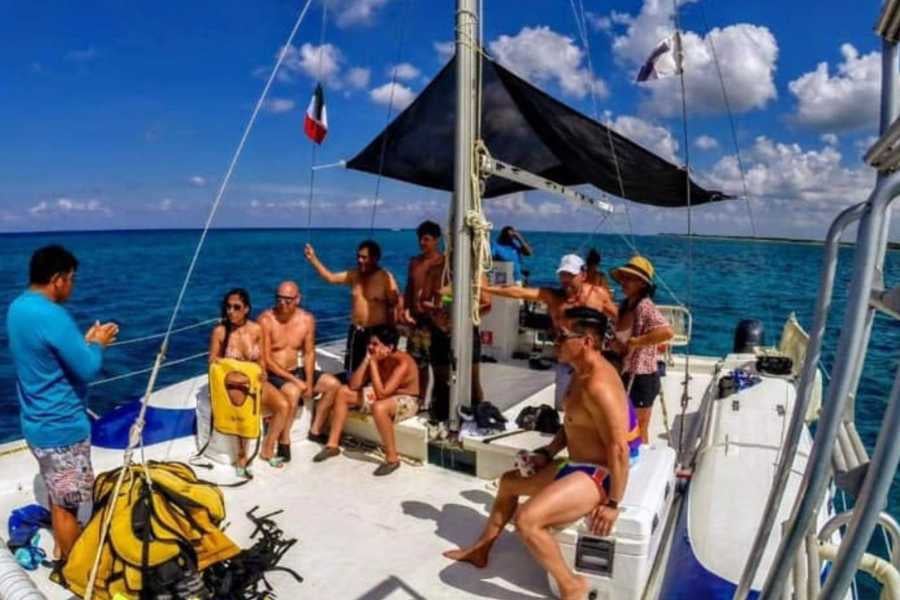 A tour guide briefs excited travelers on a catamaran before they explore the stunning blue waters.