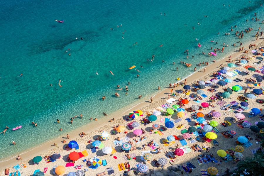 Many people are relaxing on the white sand of the beach