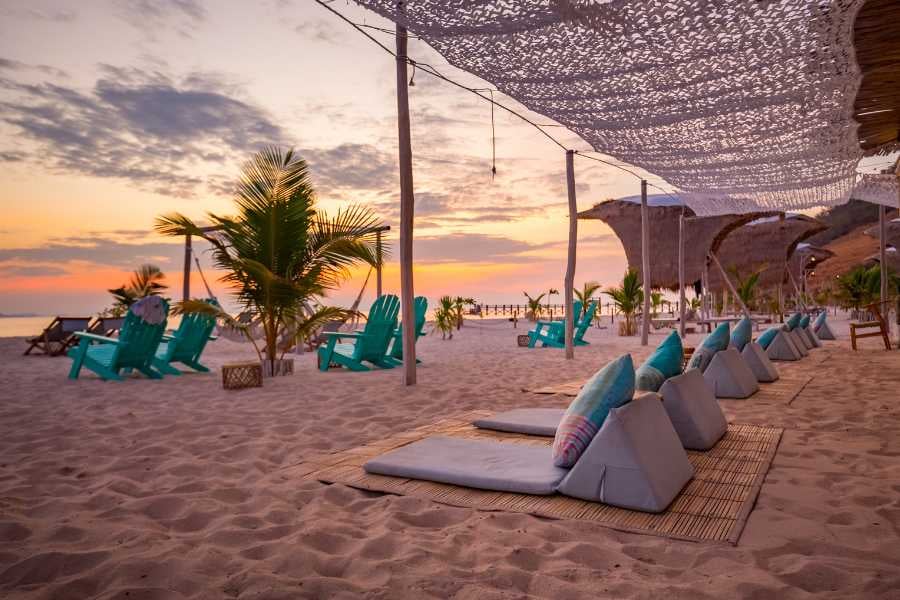 Cozy cushions and chairs set for a dreamy sunset by the beach.