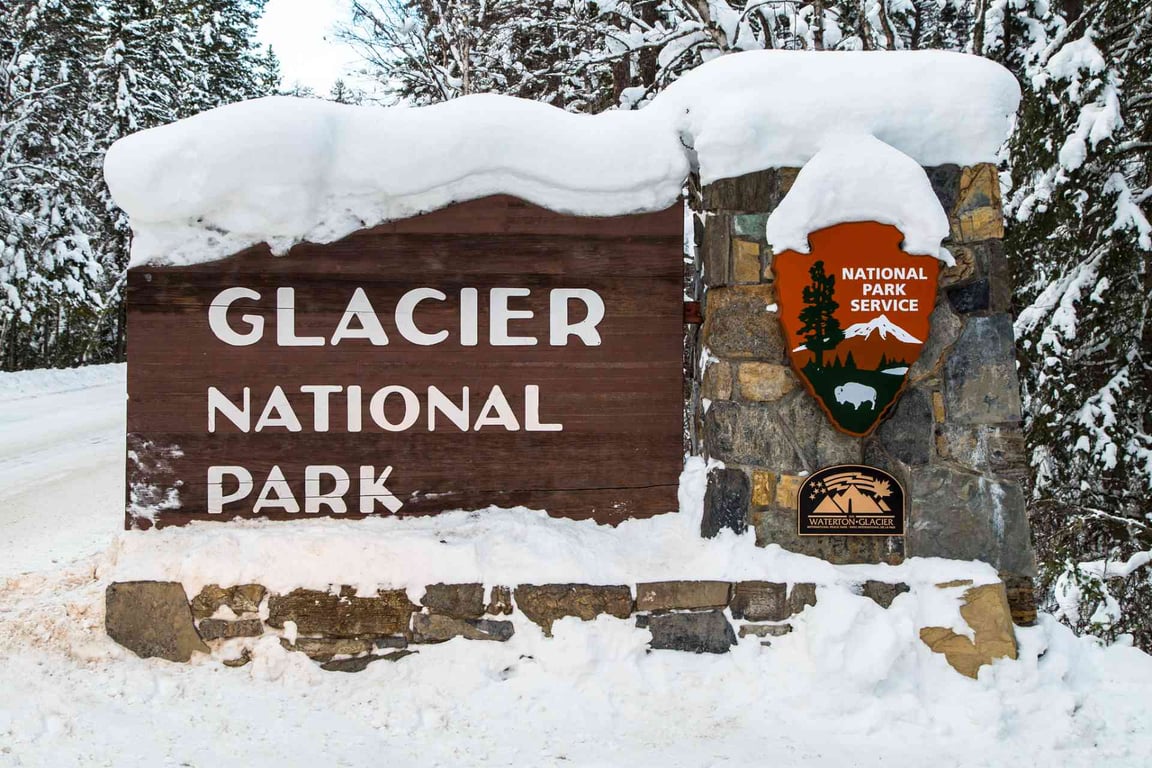 A snow covered Glacier National Park sign