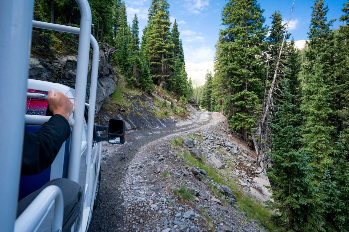 off-road truck going up narrow road on mountain