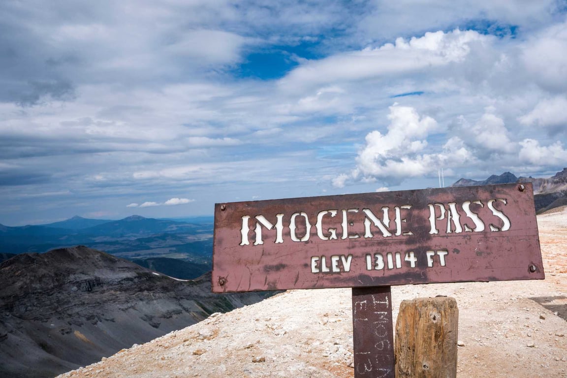 sign for "imogene pass" amidst the mountains