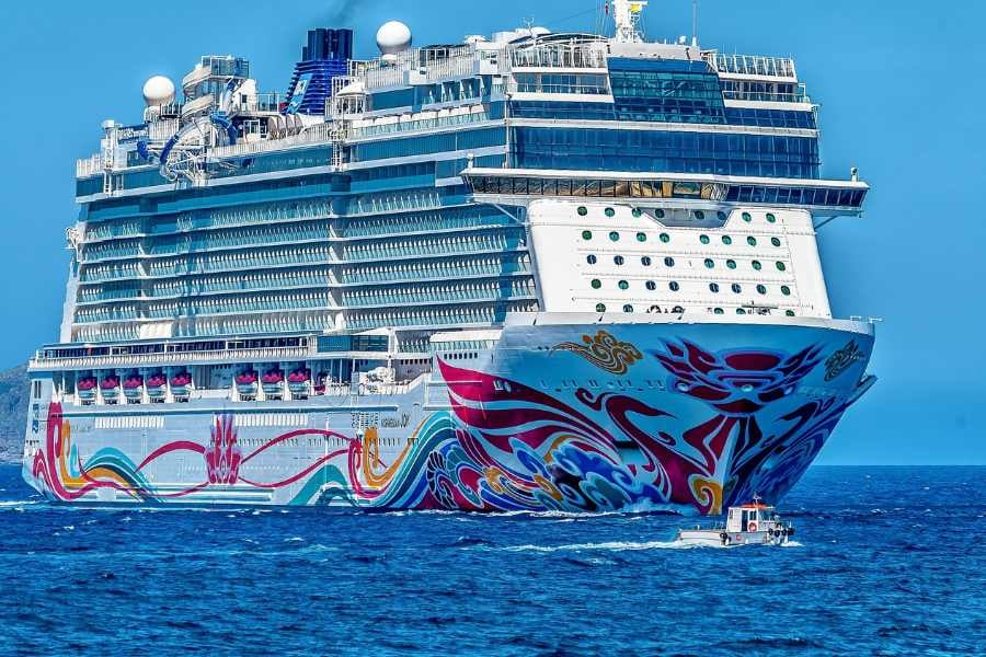 Vibrant cruise ship with colorful designs sails the open ocean, embodying fun and excitement.