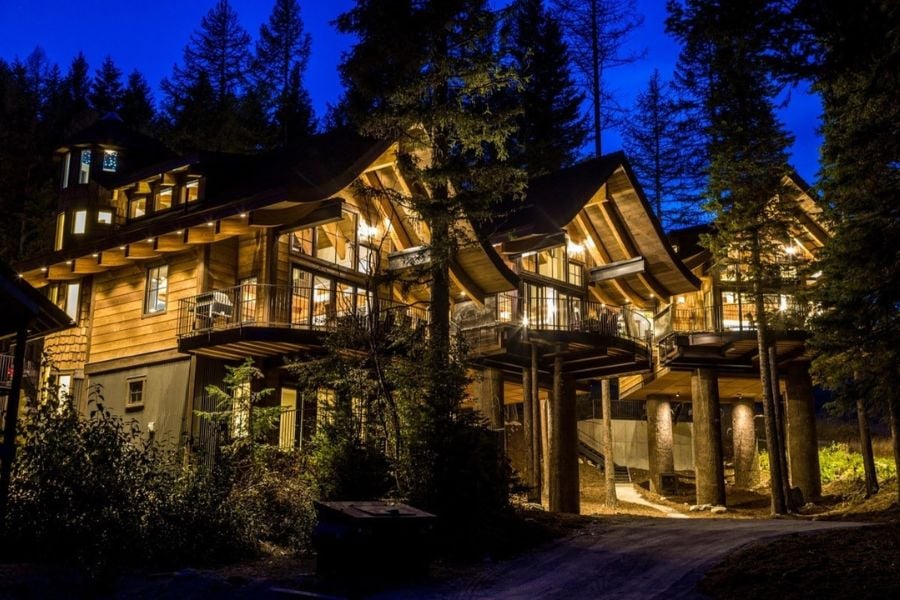 A glowing lodge lights up the forest night.