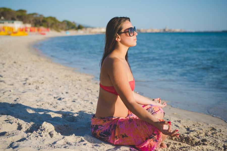 A woman is doing yoga on the beach