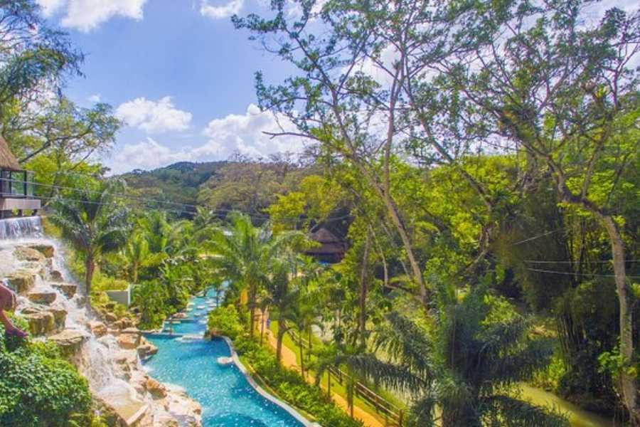 A stunning resort with a waterfall, winding pools, and lush gardens creates the perfect setting for relaxation and fun.