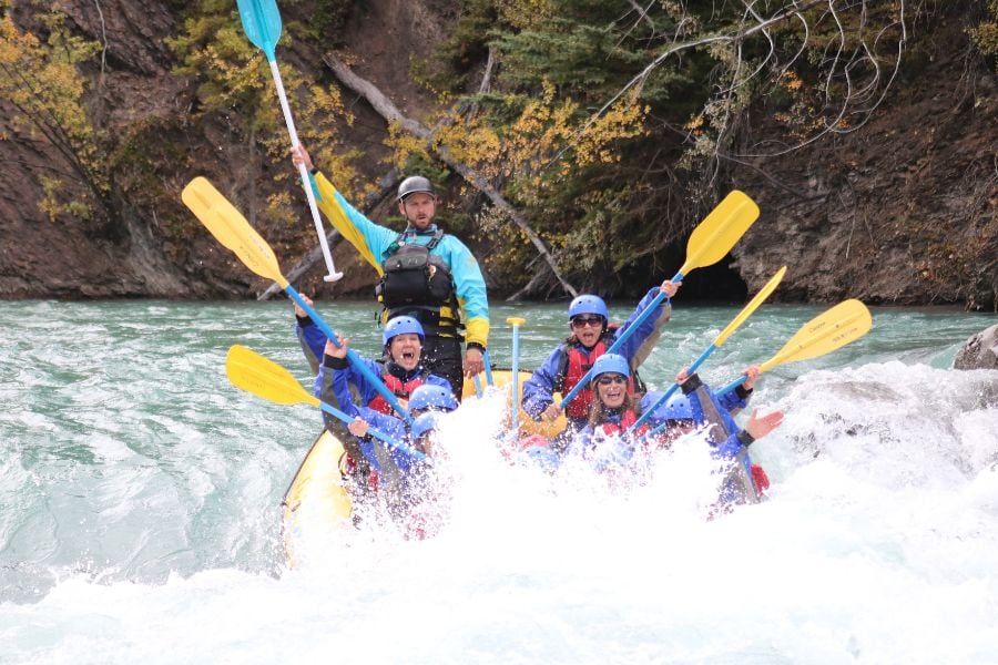 Excited rafters cheer as a big splash hits the front of the boat.