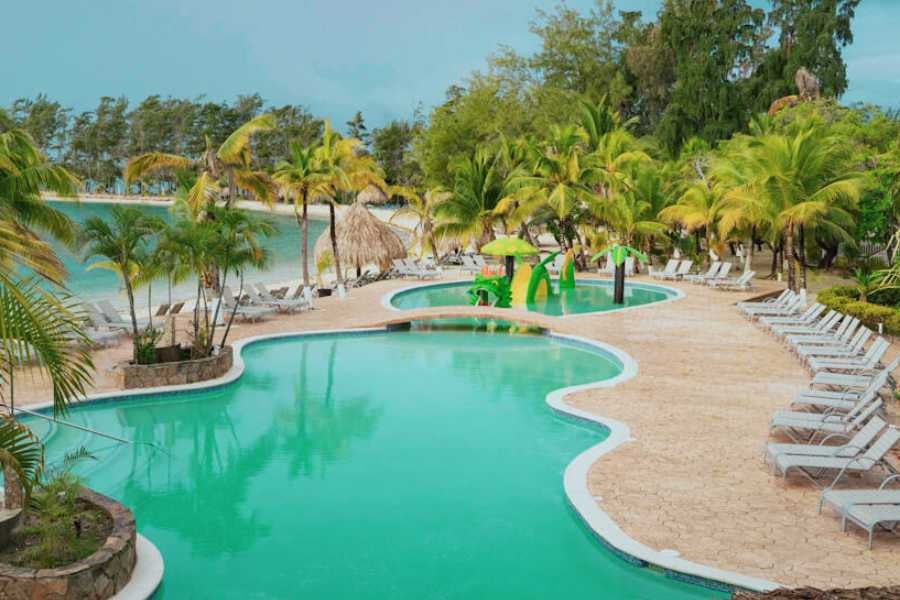 A tropical poolside retreat with lounge chairs and palm trees, overlooking a calm, turquoise lagoon.