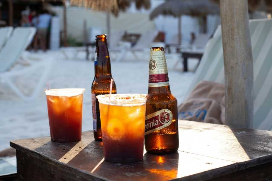 Refreshing beach drinks, including cold beers and iced cocktails, set against the relaxing backdrop of the sandy shoreline.