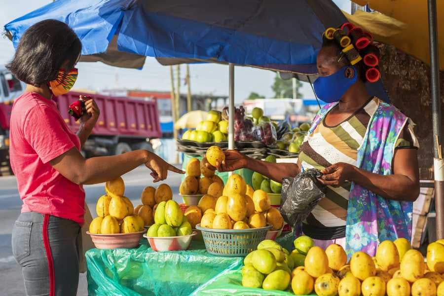 A street vendor selling fresh mangoes at a busy market.