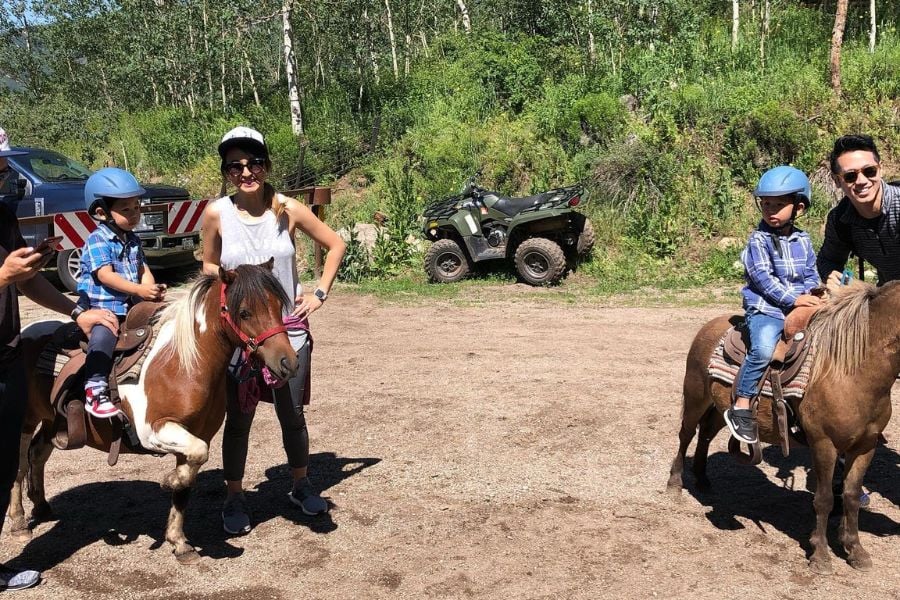 Kids enjoy pony rides with family in Vail’s mountain setting.