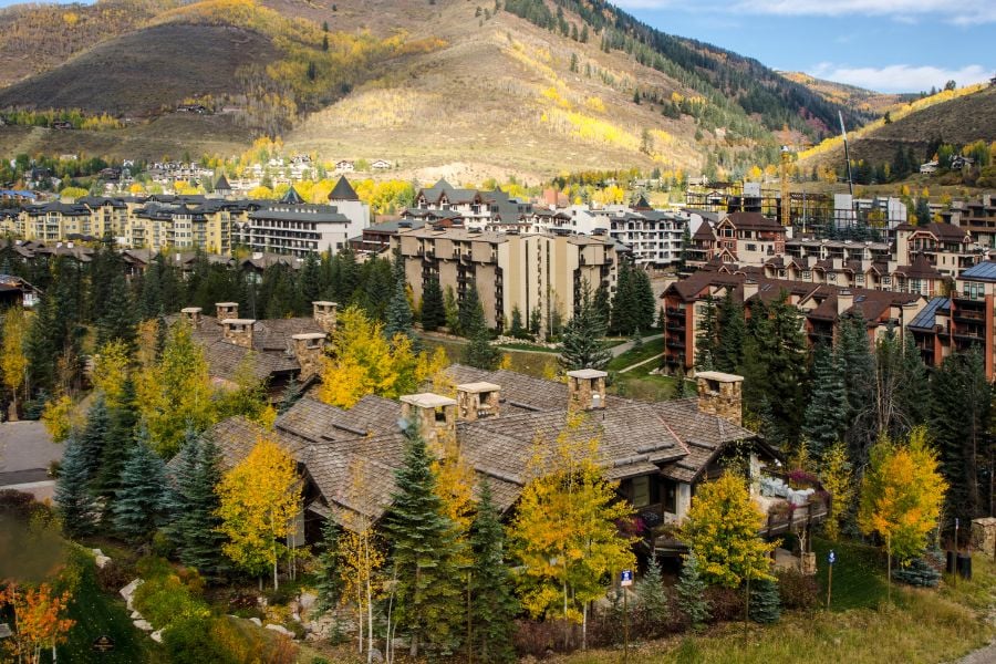 The cozy mountain town of Vail, Colorado surrounded by colorful autumn trees.