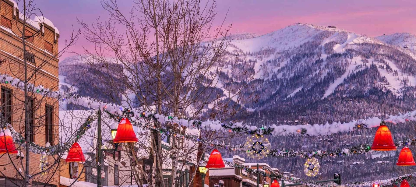 a photo of downtown whitefish with holiday decorations and mountain backdrop