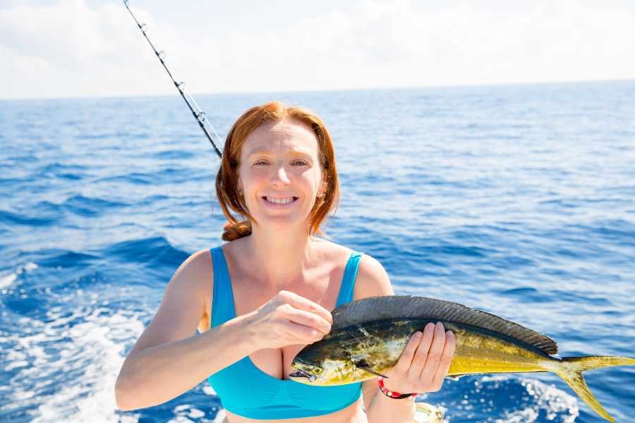 A woman holds a fish in her hands