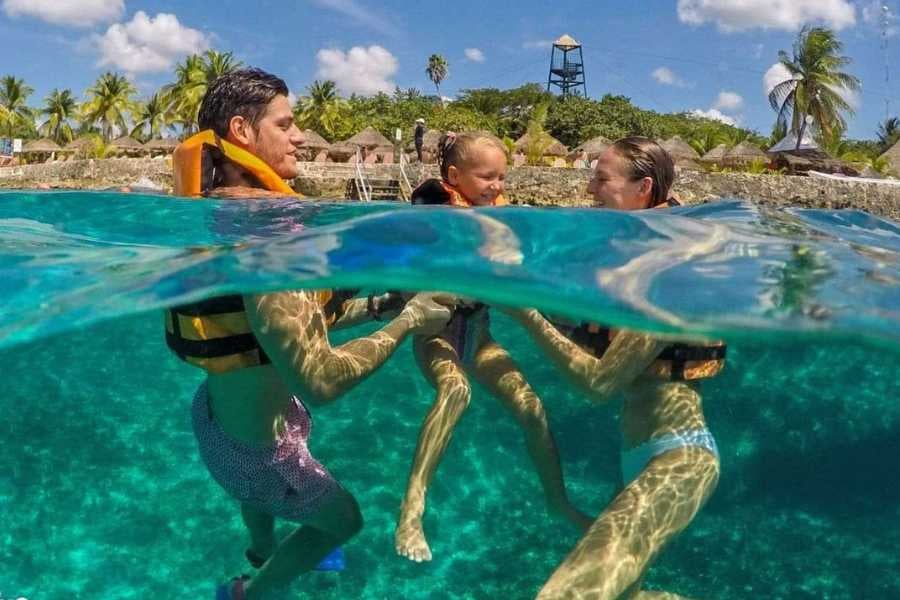 A happy family floats in clear blue water, sharing a fun snorkeling adventure together.