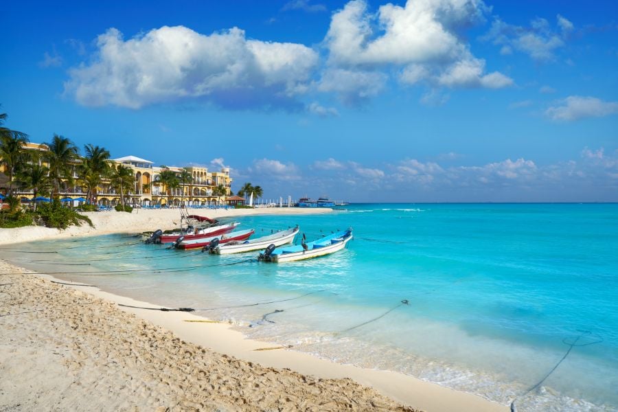 Boats rest on the turquoise shore of Playa del Carmen’s soft sandy beach.