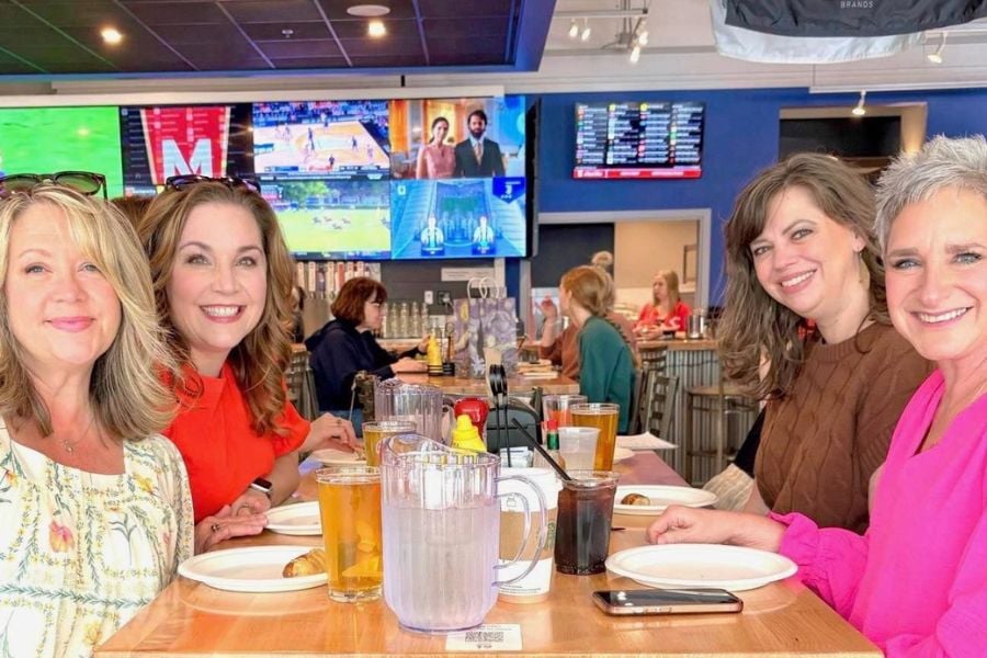 Friends share laughs and drinks at a fun, lively sports bar.