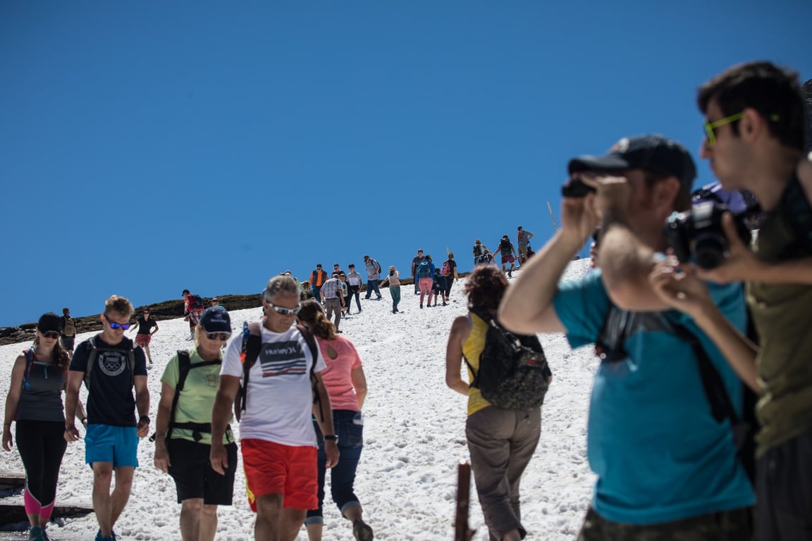 people in shorts walking on snowy hike