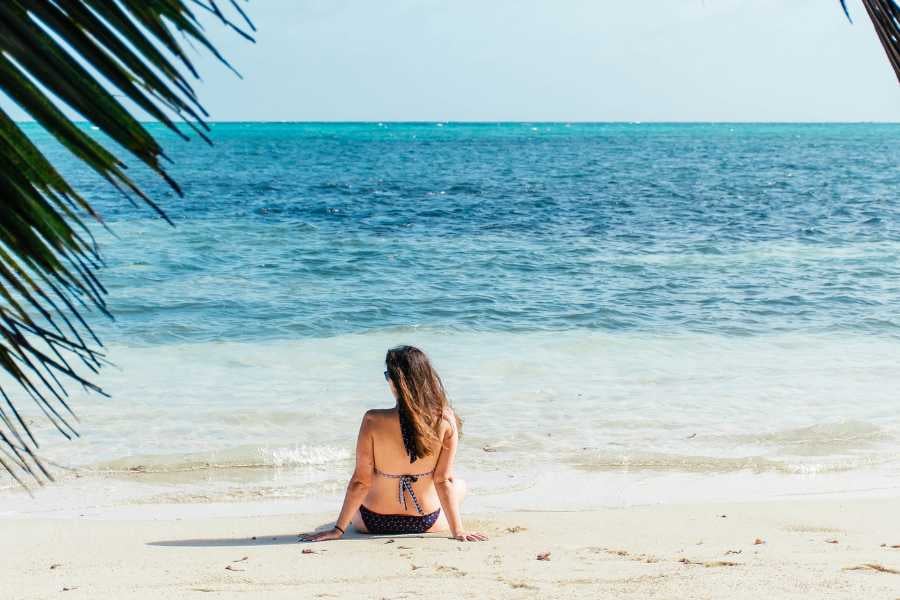 A girl is relaxing on the white sand by the beach