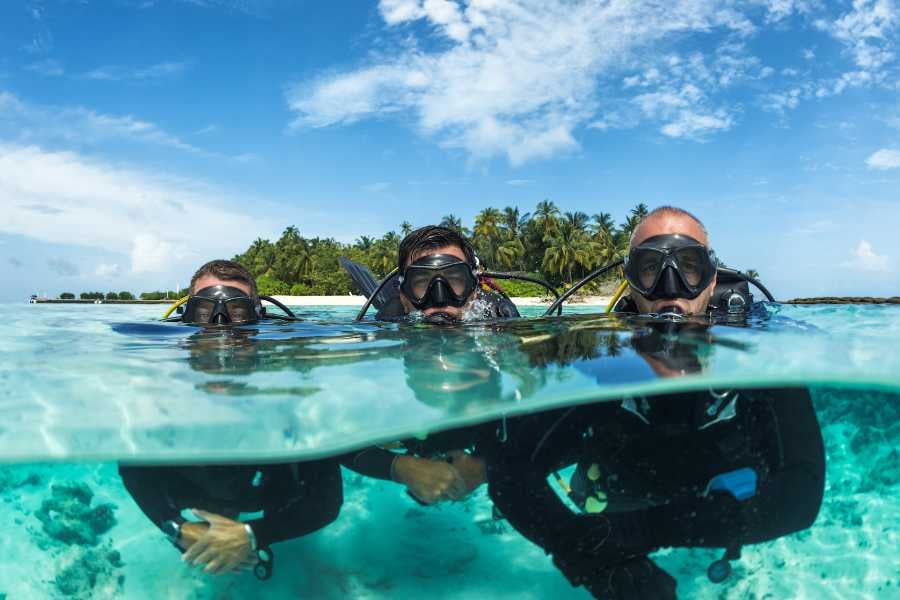 Three divers are going into deep water for a dive