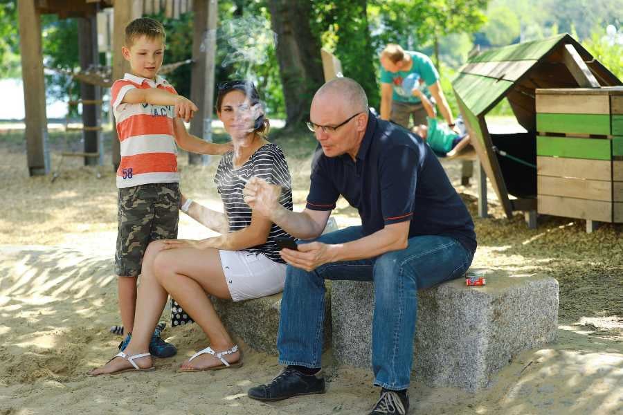 A family spending quality time together at the park, with playful moments under the sun.