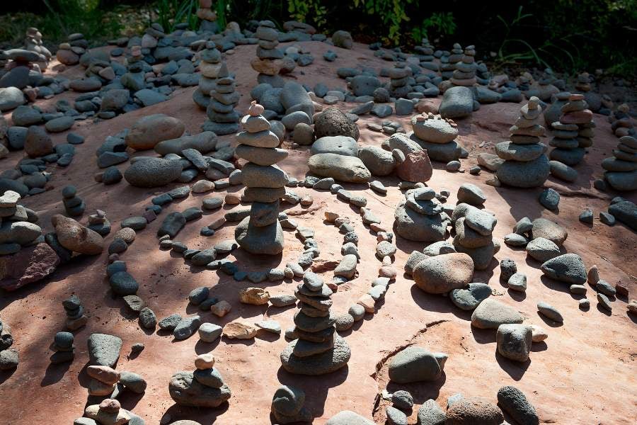 Small rocks are stacked in circles, creating a peaceful desert design.