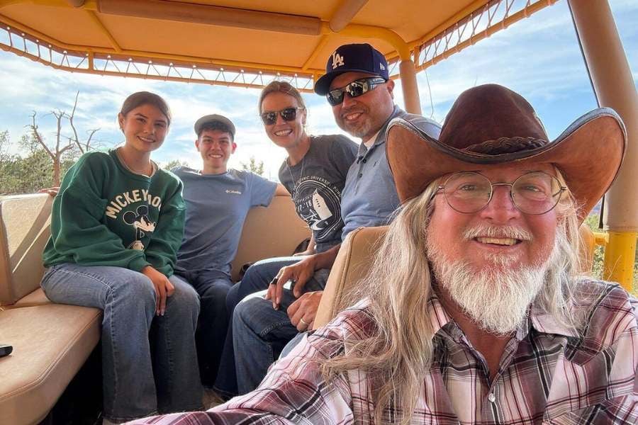 Tour guide snaps a selfie with a happy group enjoying their desert ride.